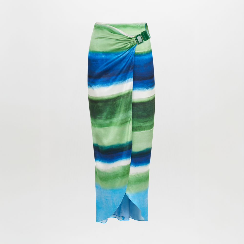 A long skirt with a tie-dye pattern in shades of blue and green, featuring a wrap design and a belt buckle detail at the waist. The Adrianne Skirt Washed Emerald Blue is final sale and not eligible for return.