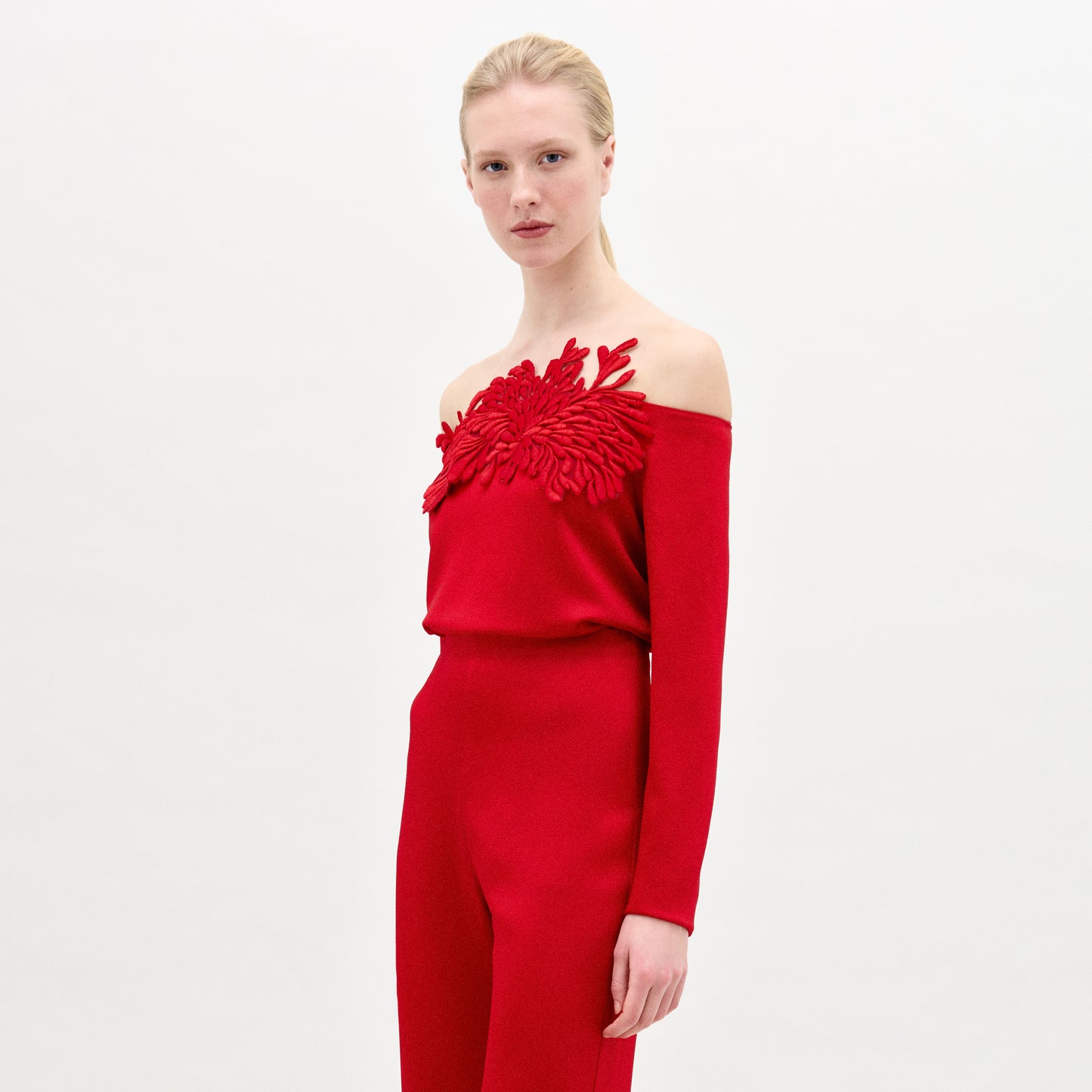 A blonde woman stands against a plain background wearing the Belinda Blouse in color Rouge