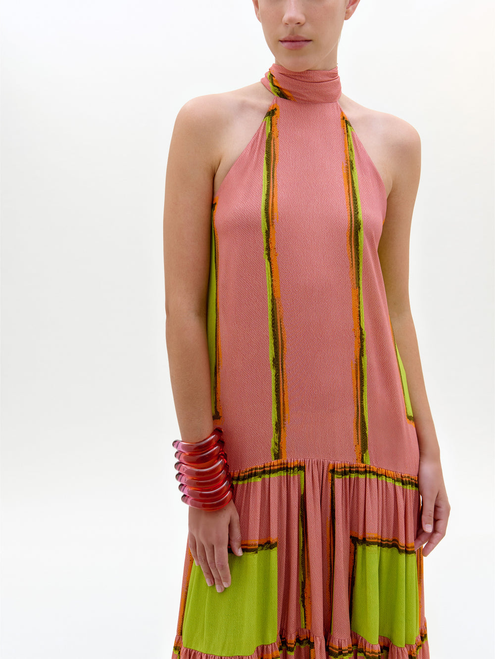 Woman wearing a pink and green dress with a white background