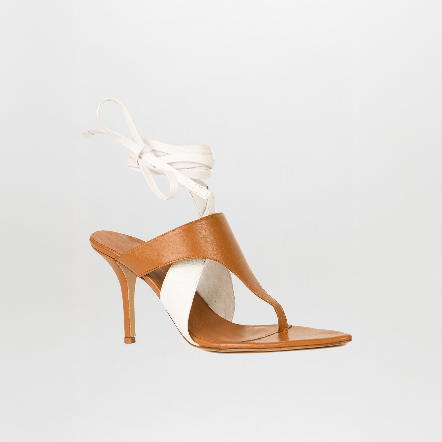 The Domenico Heels Beige/White from GIA Couture feature brown Italian leather, white side panels, thong toe, and white ankle wrap straps, shown against a plain background.
