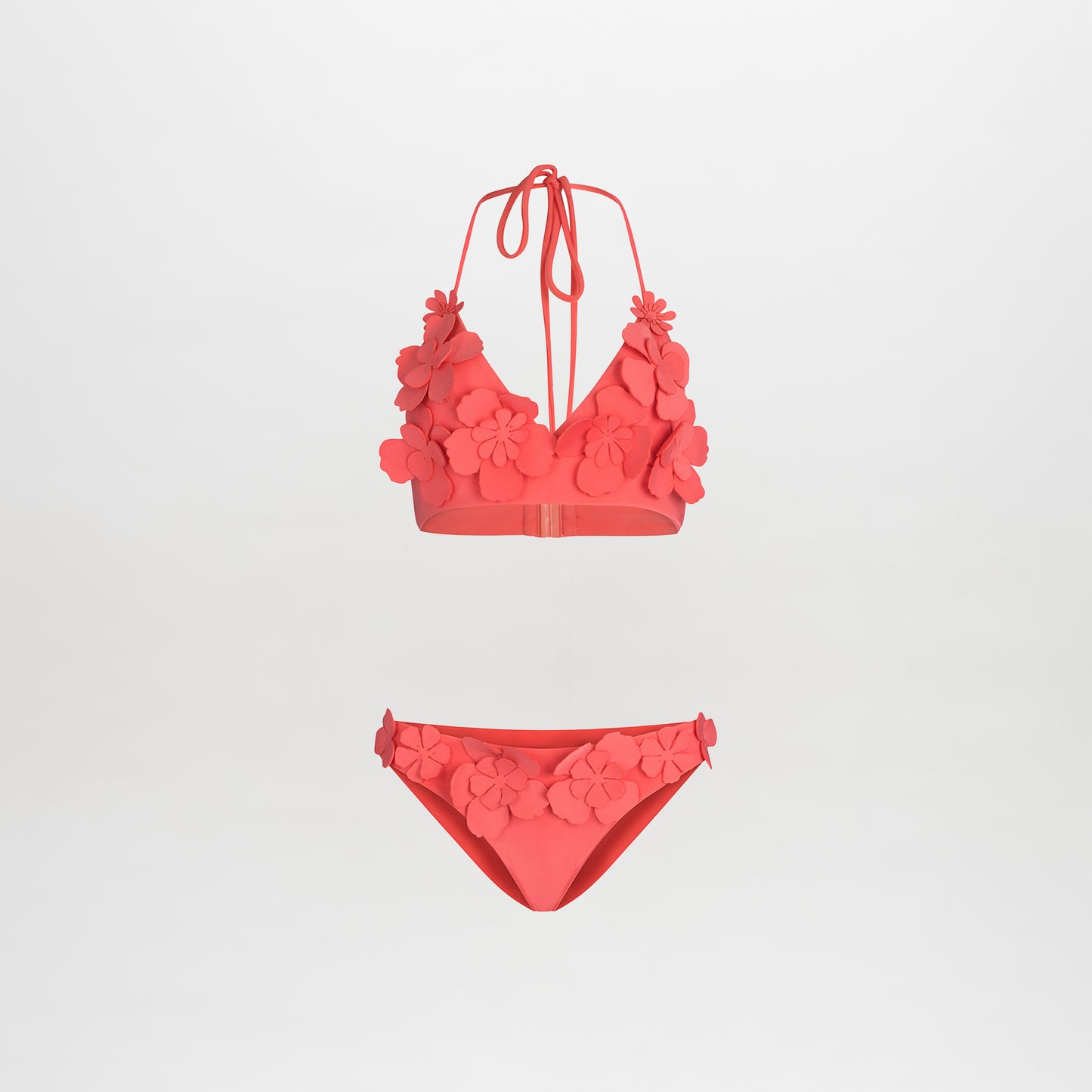 The Felisa Top + Fermina Bikini is a vibrant pink set featuring 3D floral details on the halter V-neckline top and side bottoms, showcased against a plain white background.