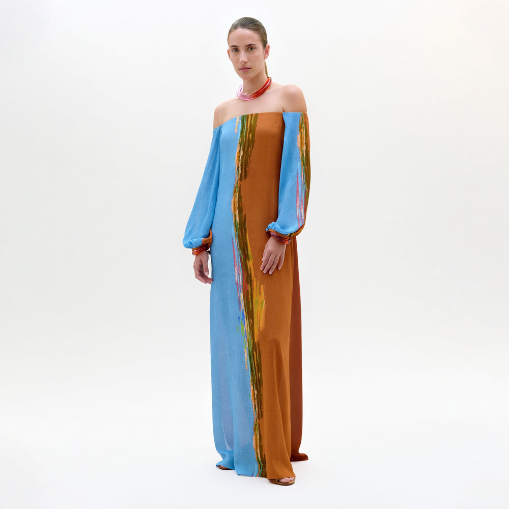 Woman wearing a colorful off-shoulder dress on a white background