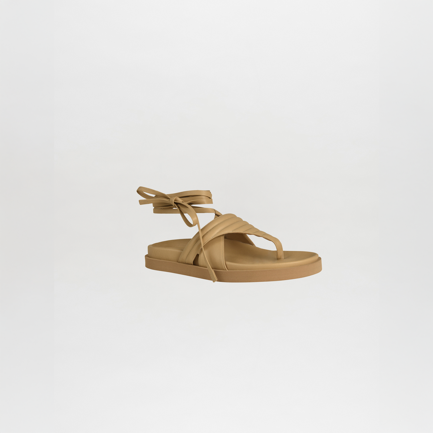 The Kristina Sandals Beige feature thick crisscross straps and ankle ties, crafted from luxurious Italian calf leather, shown against a plain white background.