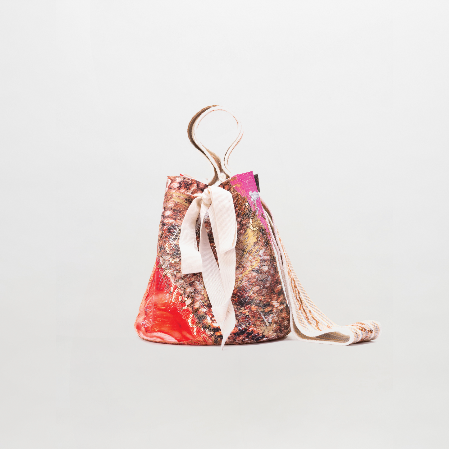 Drawstring bag with colorful pattern and ribbon on a light gray background