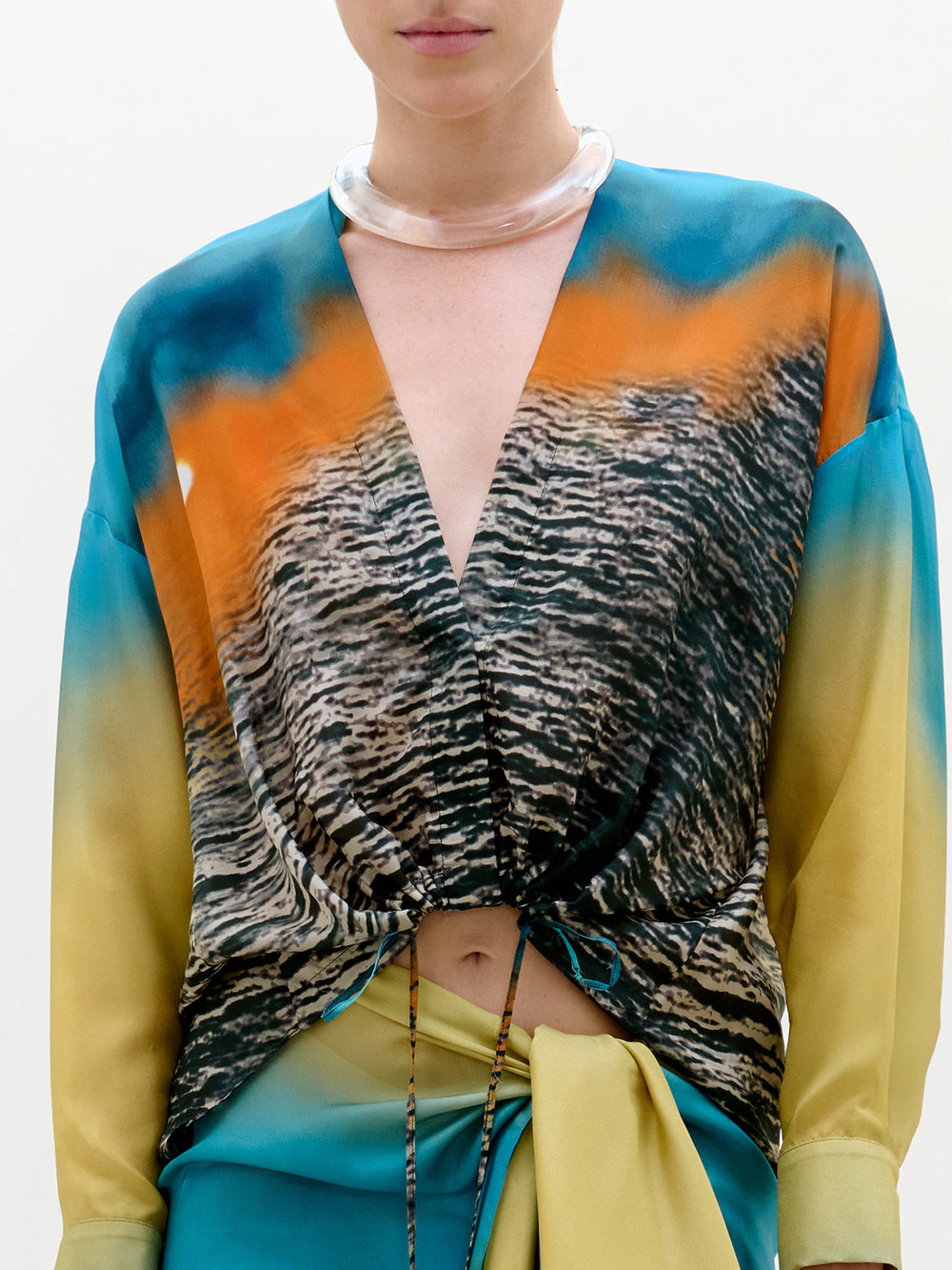Person wearing a colorful outfit with a zebra print top on a white background