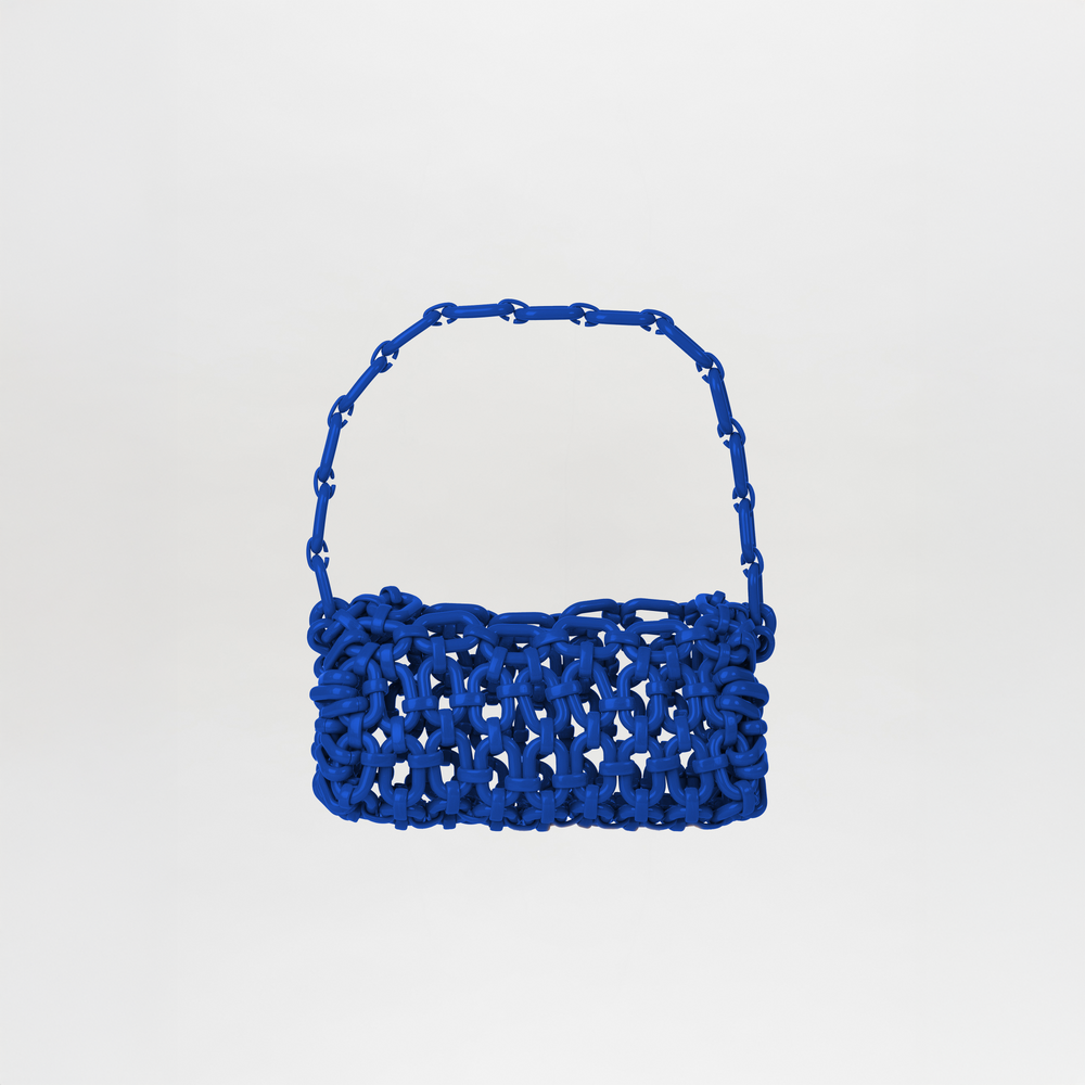 The Piceno Handbag Blue features a royal blue hue, chunky interlaced design, and a matching Italian resin chain strap, shown against a plain white background.