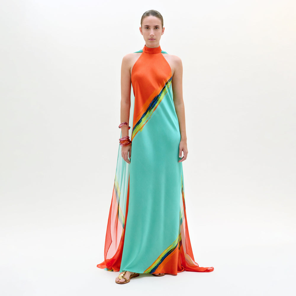 Woman wearing a colorful dress with an orange top and teal skirt on a white background