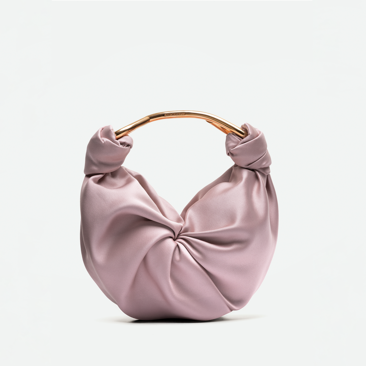 The Sofia Bag (Small) is a light pink satin handbag made from luxurious Italian fabric, featuring a round gold-toned handle and a knotted front design, shown against a plain white background.