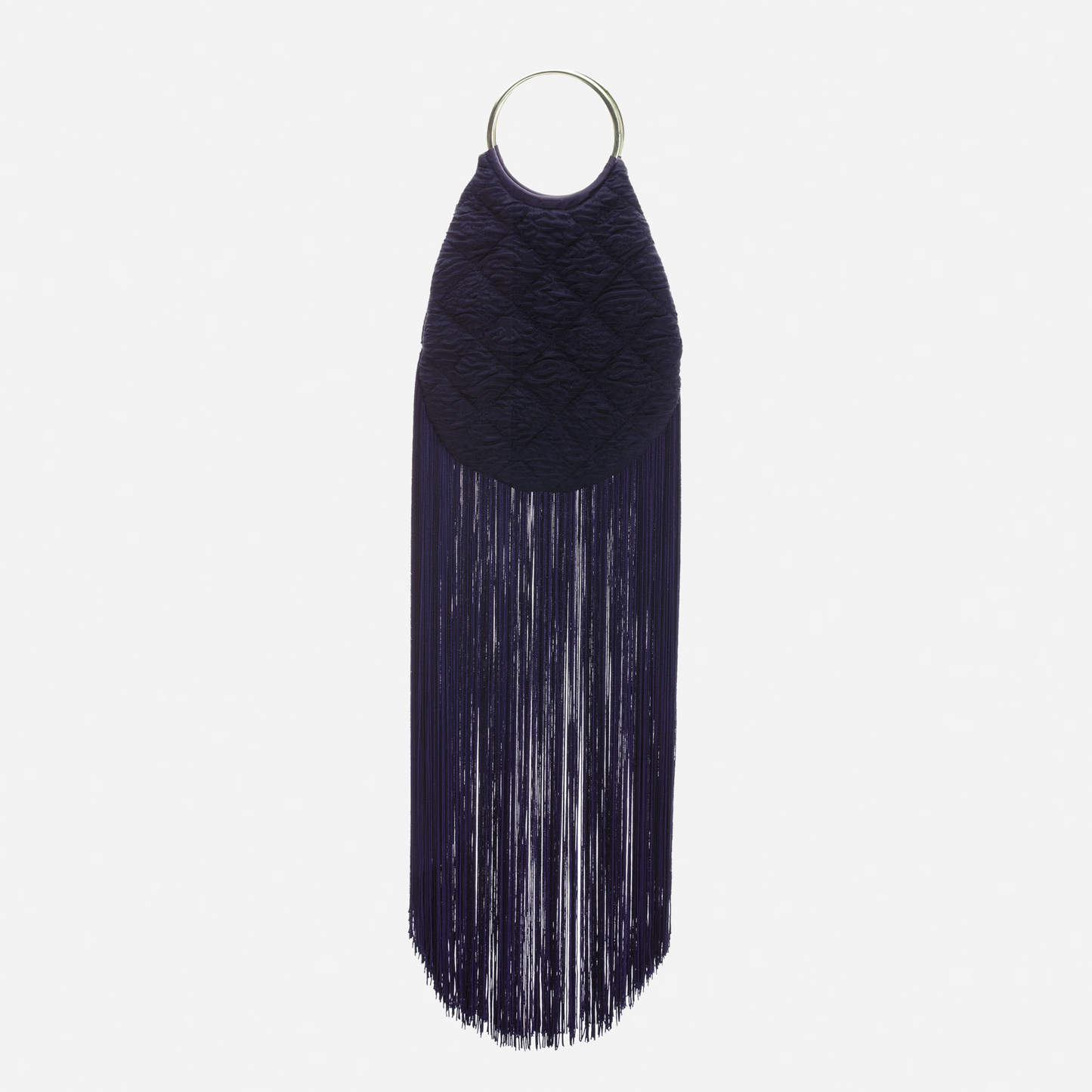 The Toblach Bag is a dark navy blue jacquard bag featuring a quilted, oval-shaped upper section, a large metallic top handle ring, and long straight fringe at the bottom, shown against a plain white background.