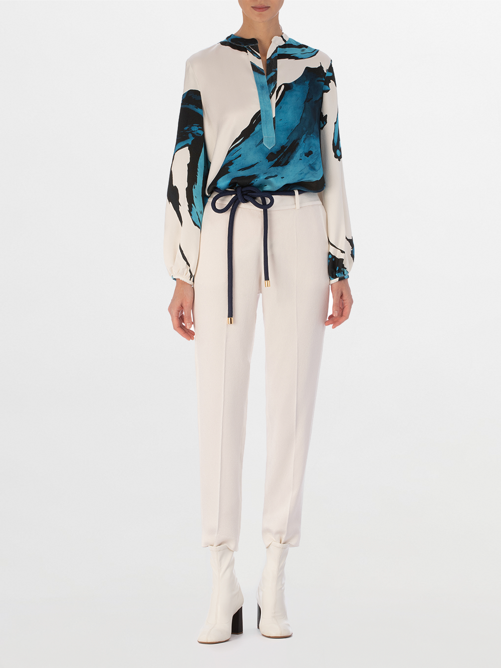 A white Triora Blouse Multi Abstract Waves with bold blue and black abstract print, featuring long sleeves and a V neckline with a tie.