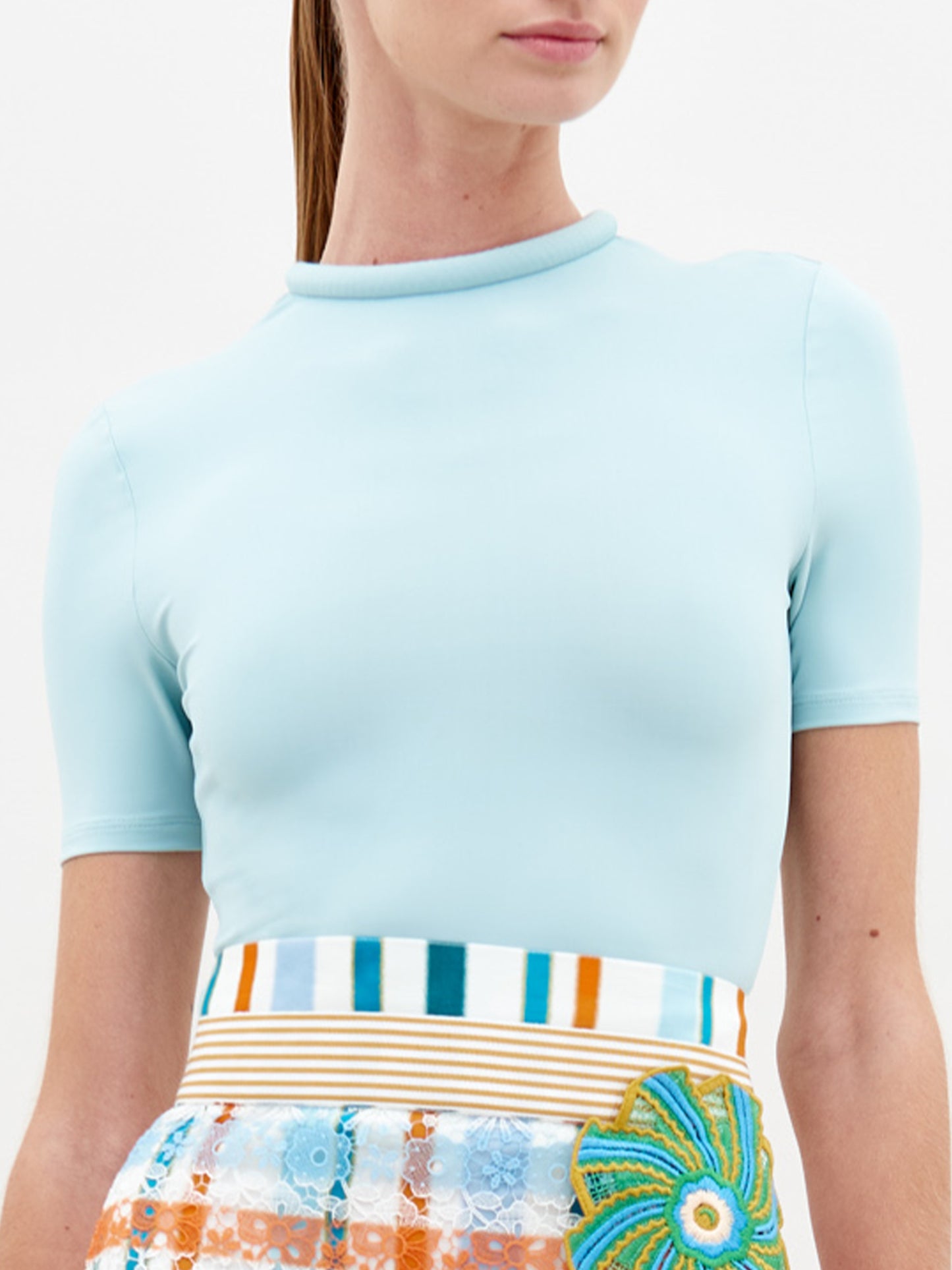 A person wearing the Varinia Tshirt in color Turquoise on a white background.