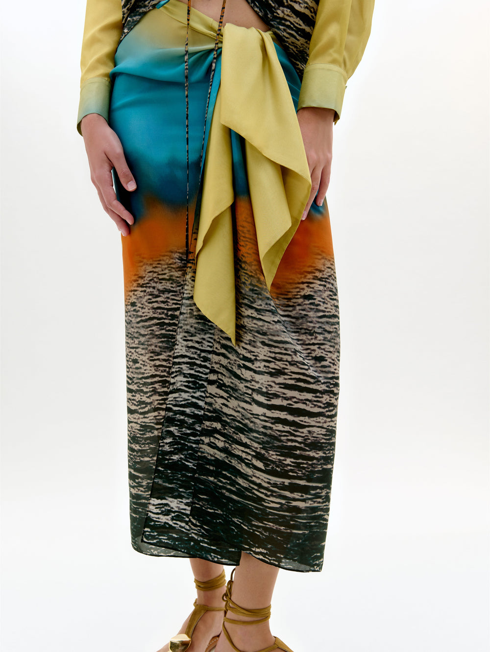 Person wearing a colorful outfit with a patterned skirt on a white background