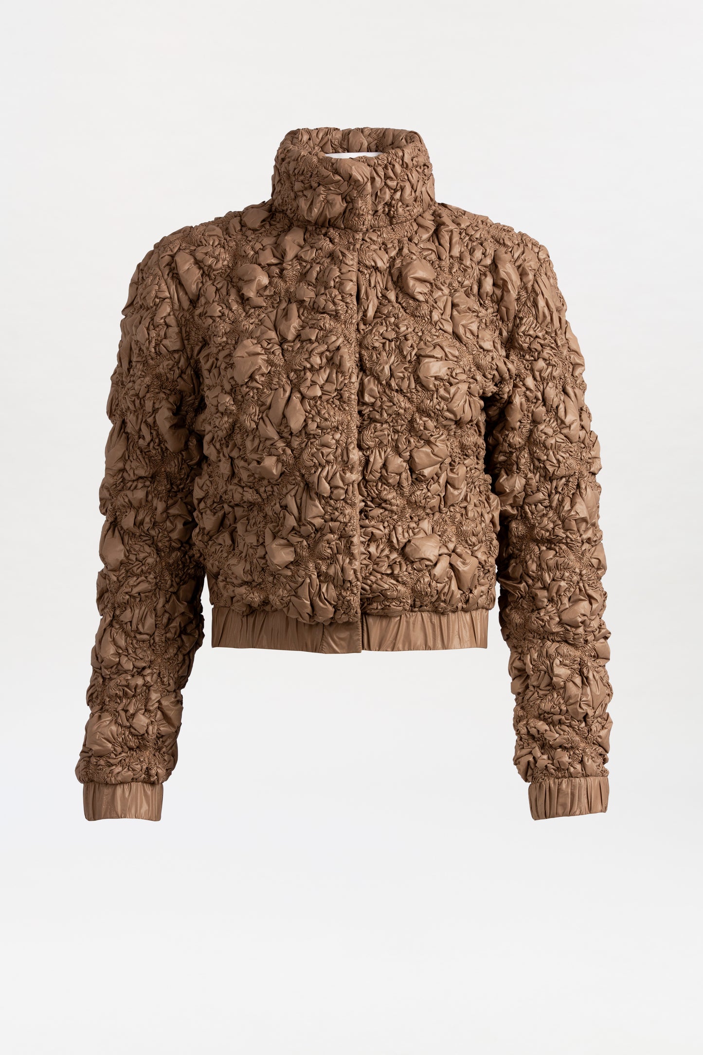 The Zalta Jacket showcases a brown Italian textile with ruched, crinkled texture. Designed with a high collar, long sleeves, and elastic cuffs and hem for a chic finish.