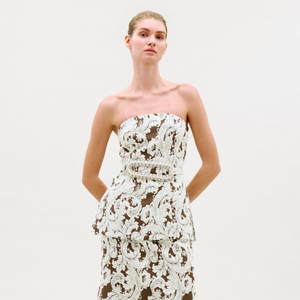 Model wearing a strapless lace top on a white background