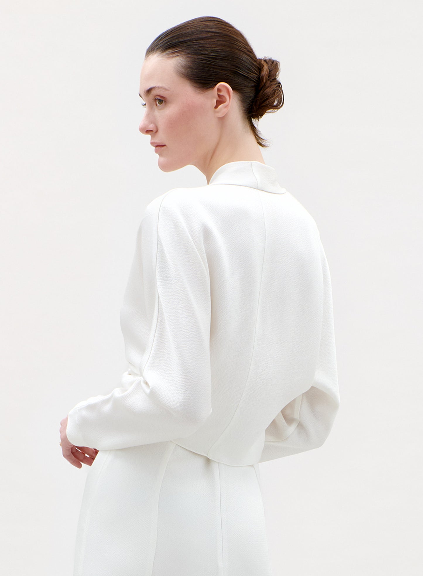 Woman wearing a white blouse on a plain background