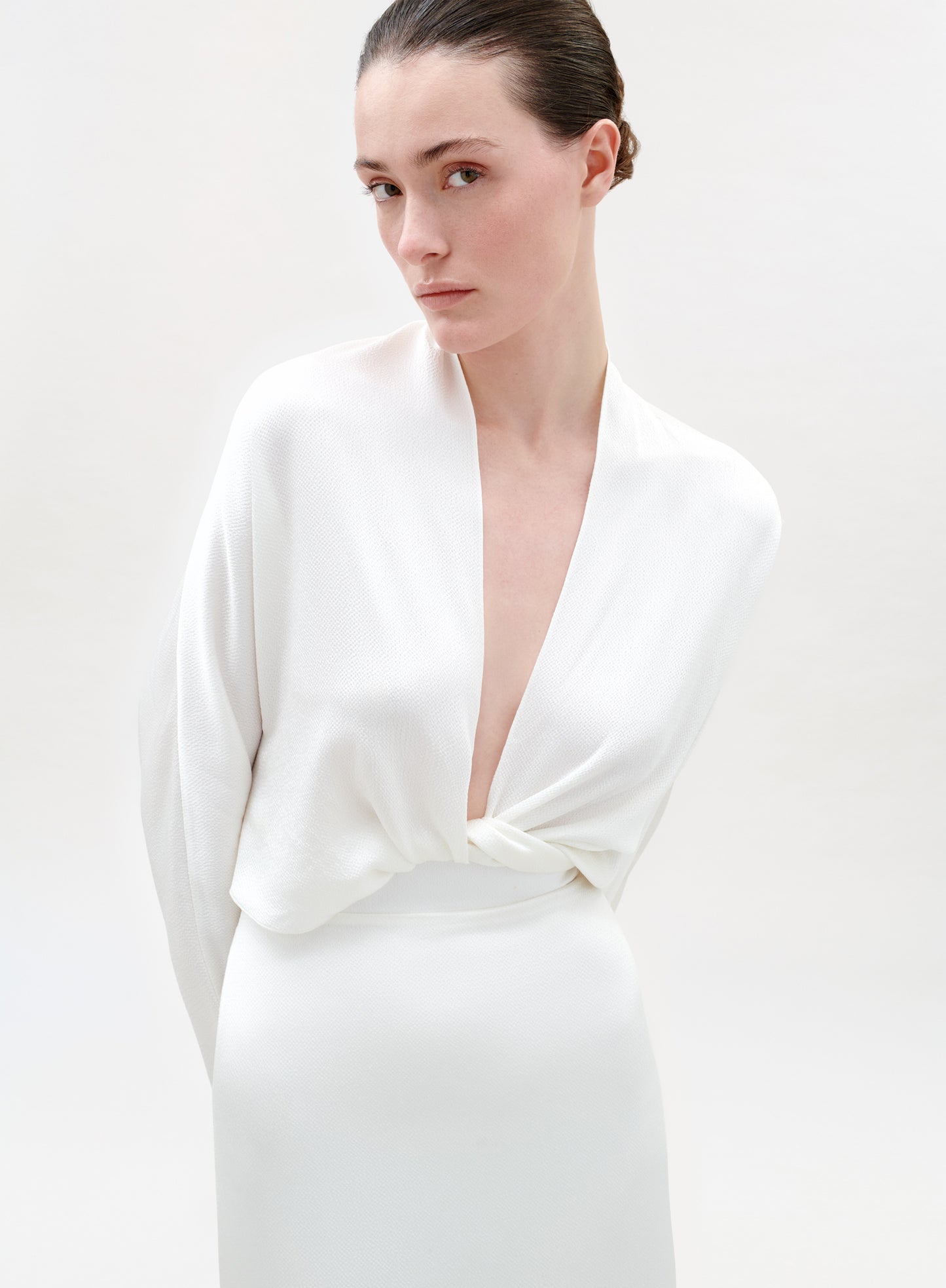 Woman wearing a white blouse on a plain background