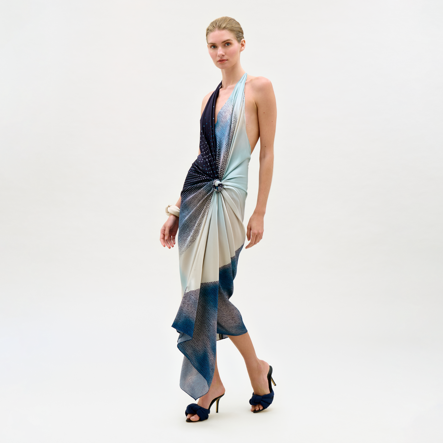Woman wearing a patterned halter neck dress on a white background
