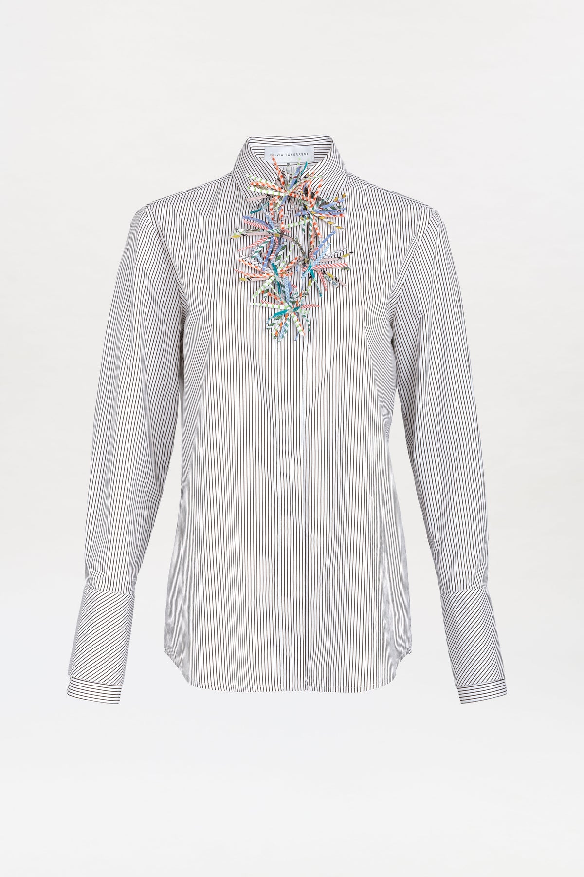 The Karena Shirt is a long-sleeve, black-and-white striped button-up featuring colorful bead and thread embroidery in an abstract pattern on the chest.