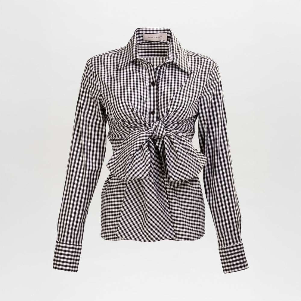 The Mercury Blouse is a long-sleeve black and white gingham shirt featuring a pointed collar and front knot detail at the waist, shown on a plain white background.