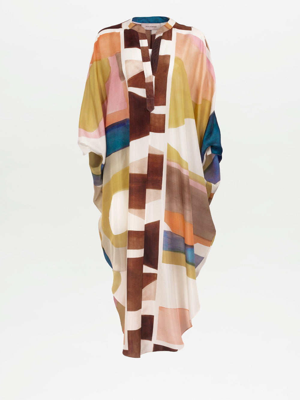 The Ilse Tunic is a loose-fitting maxi dress kaftan made from 100% Italian silk, showcasing an abstract geometric pattern in brown, pink, yellow, blue, and white on a plain white background.