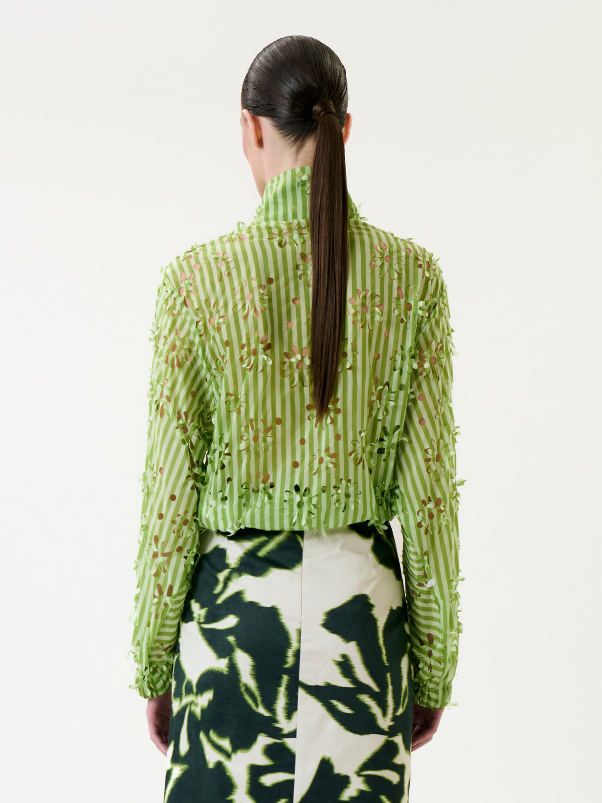 Wearing the Randy Jacket, a person with long brown hair in a ponytail is seen from the back.