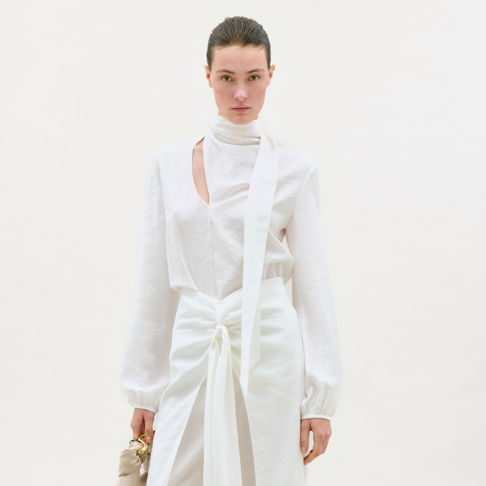 Woman wearing a white outfit with a plain background