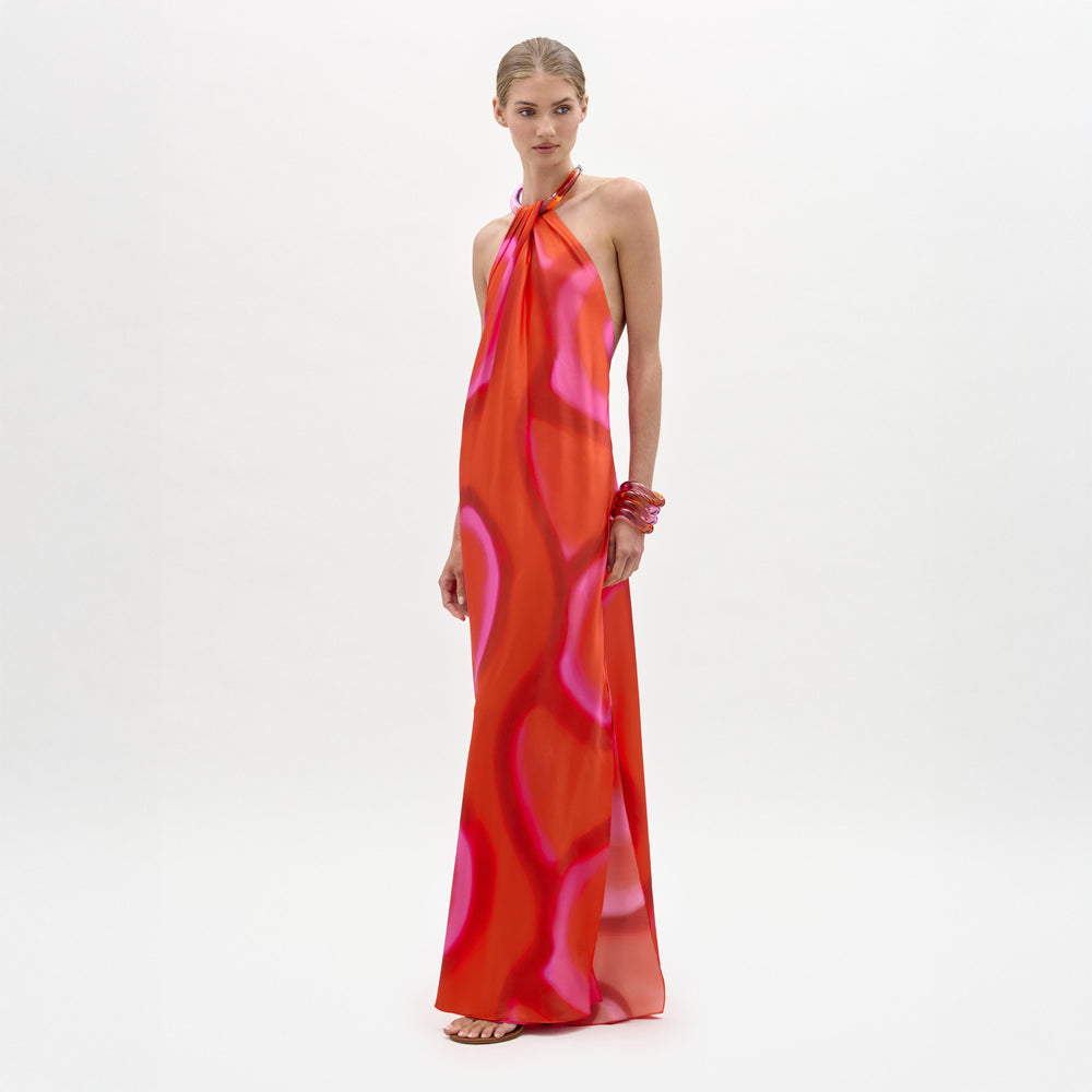 Woman wearing a vibrant orange and pink dress on a white background
