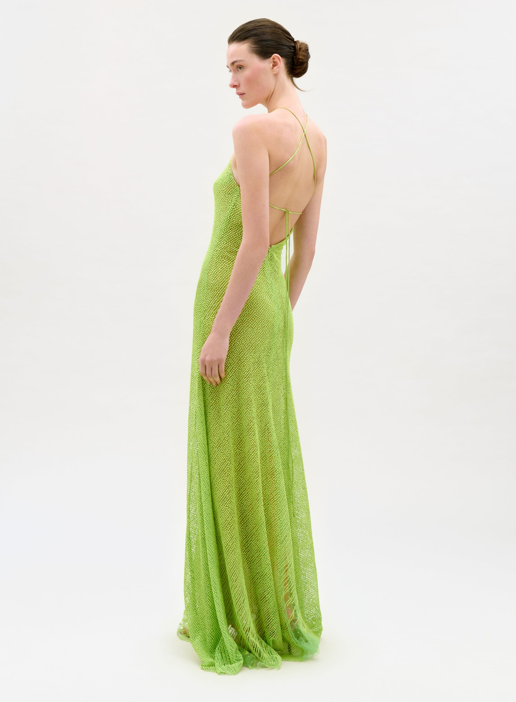Woman wearing a long green dress on a white background