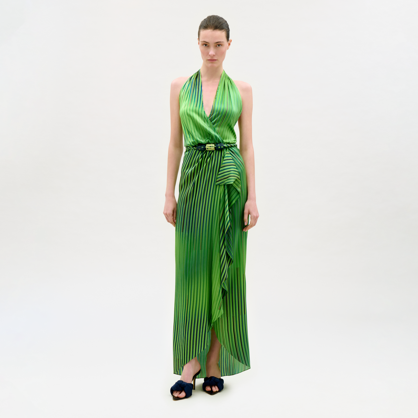 Woman wearing a green dress with vertical stripes on a white background