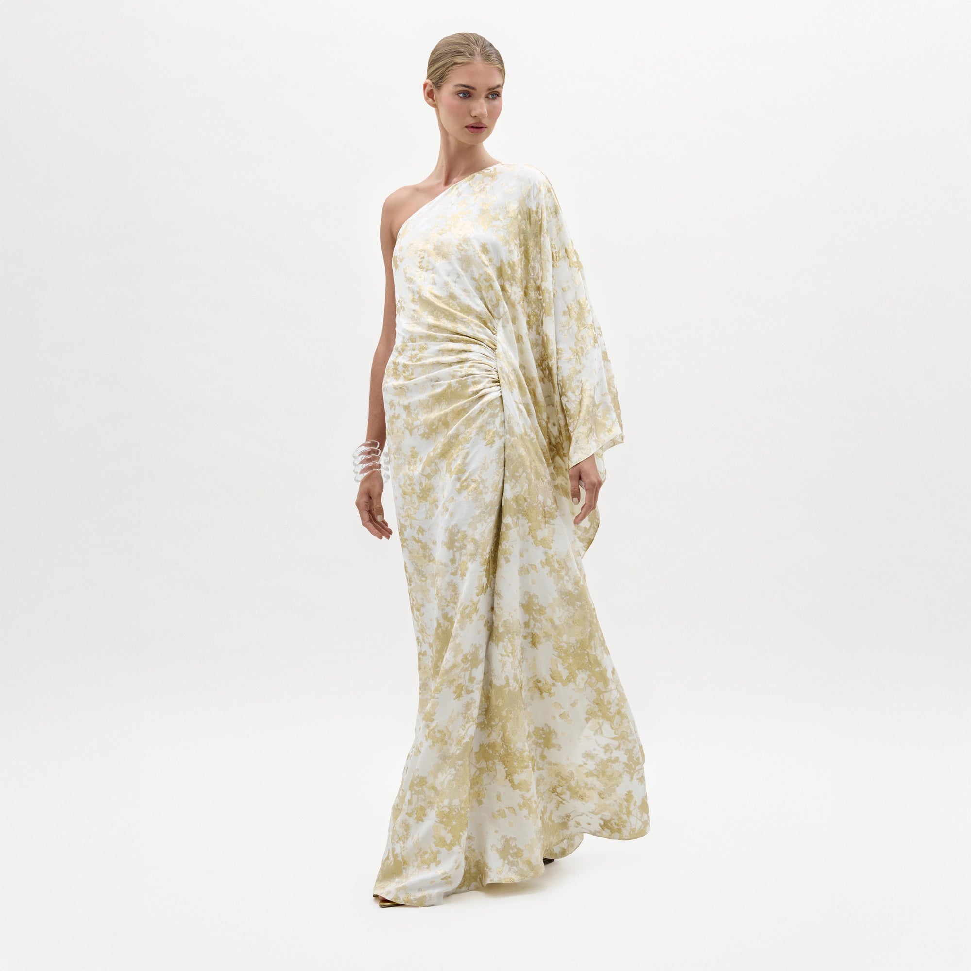Woman wearing a white and gold floral dress on a white background