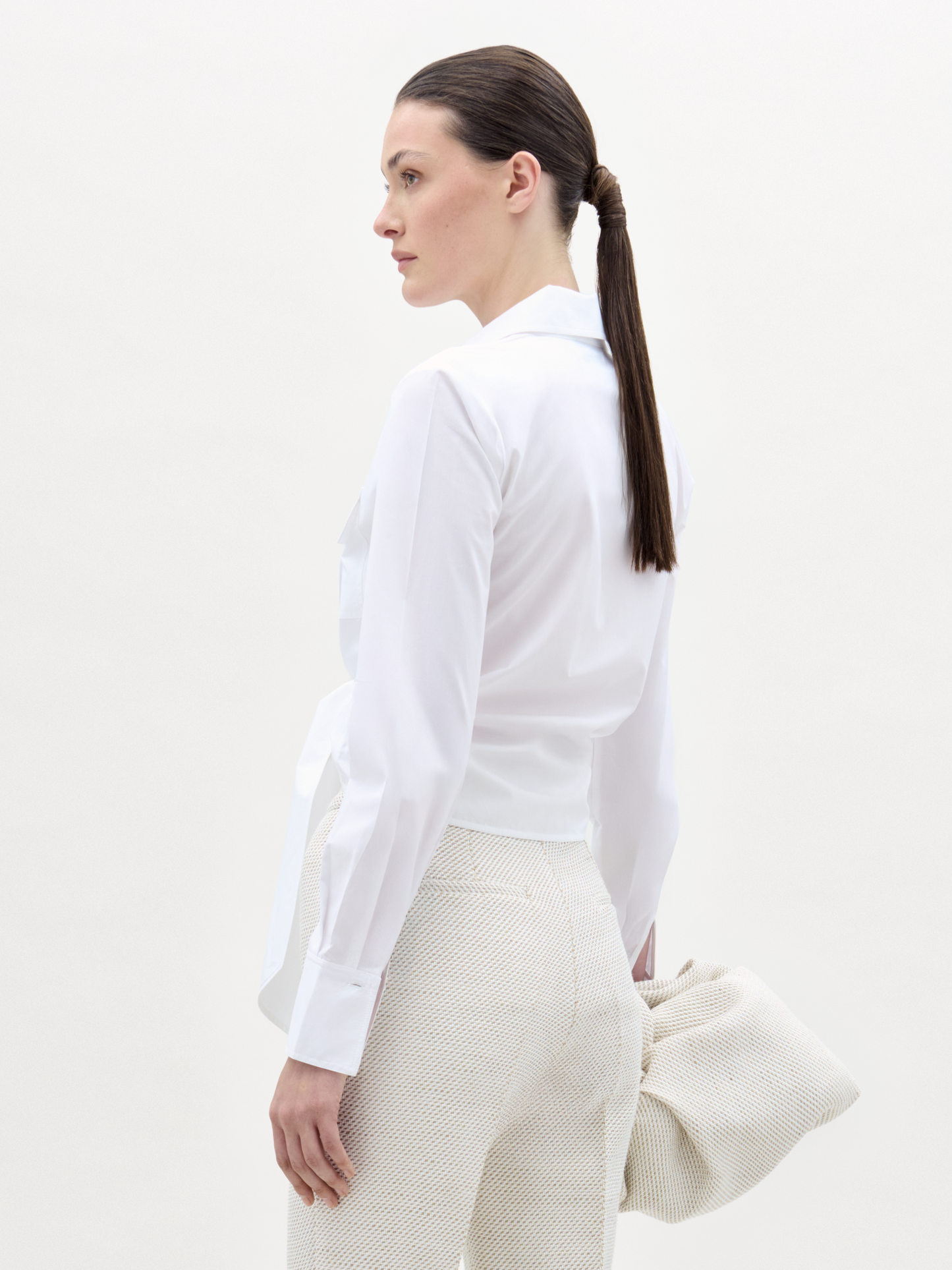 Woman wearing a white shirt and white pants with a white background