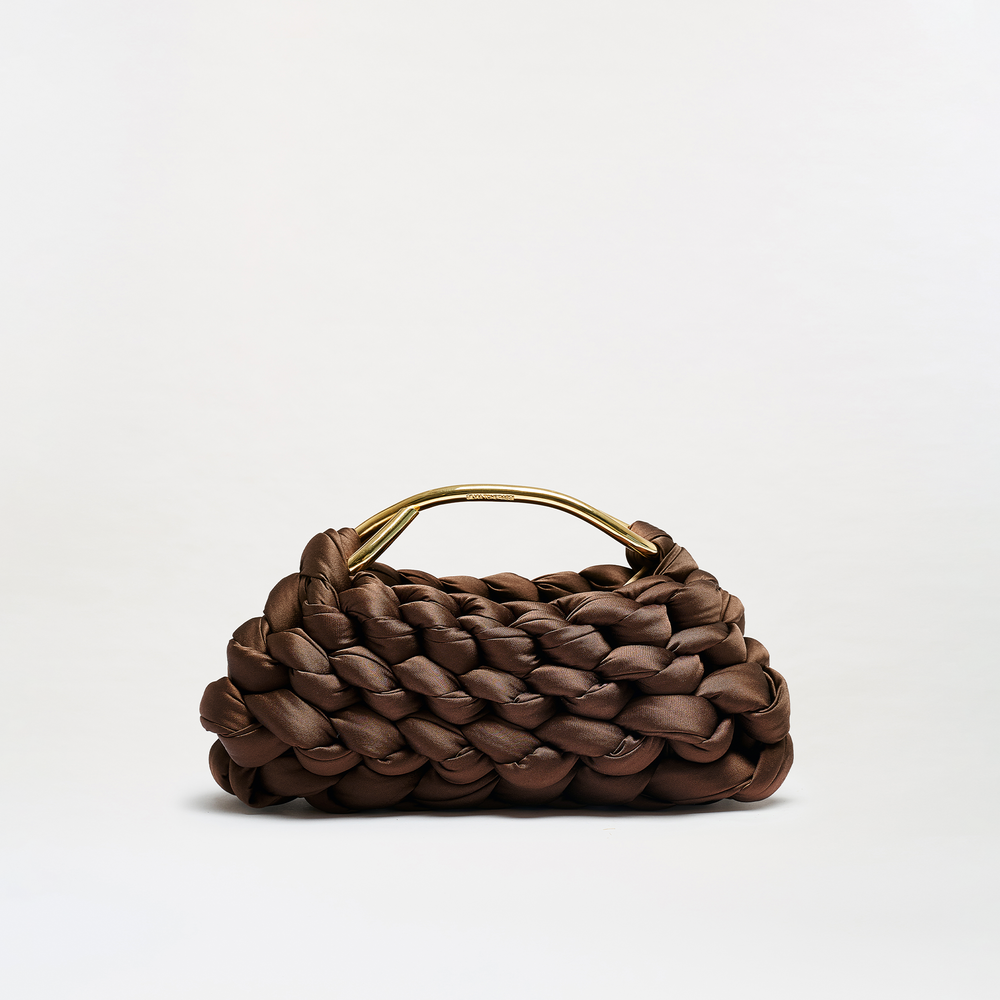 A brown woven leather handbag with a structured, braided texture and a curved gold-tone metal handle, photographed on a clean white studio background.