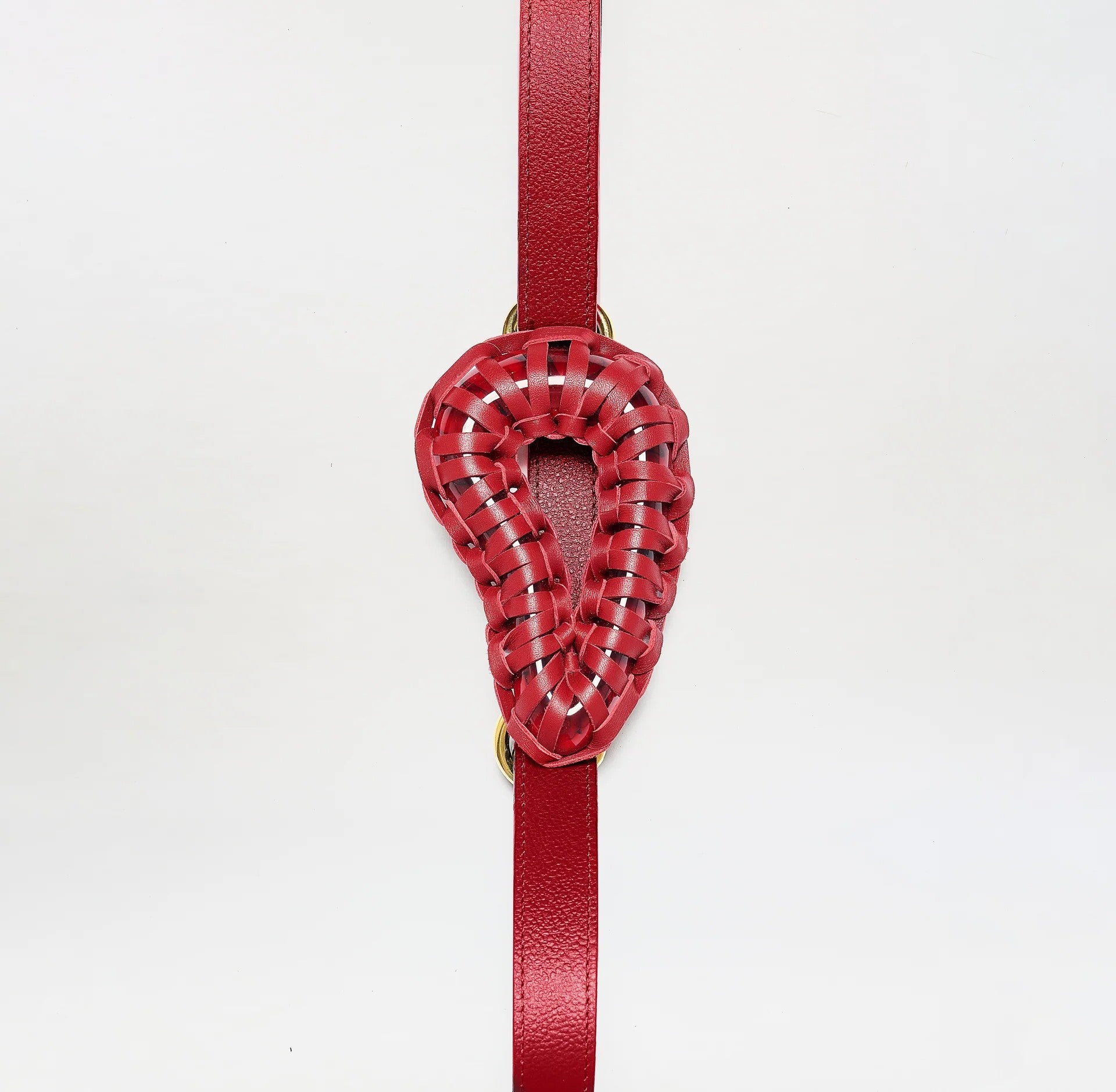 The Renata Belt, crafted from red woven Italian leather in a stylized ear shape, hangs vertically on a plain white background.