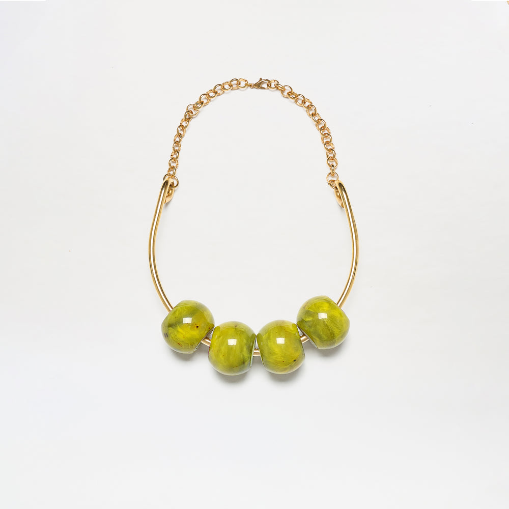 The Martini Chocker is a gold chain necklace featuring four large, glossy green beads on a curved gold bar, shown against a white background.