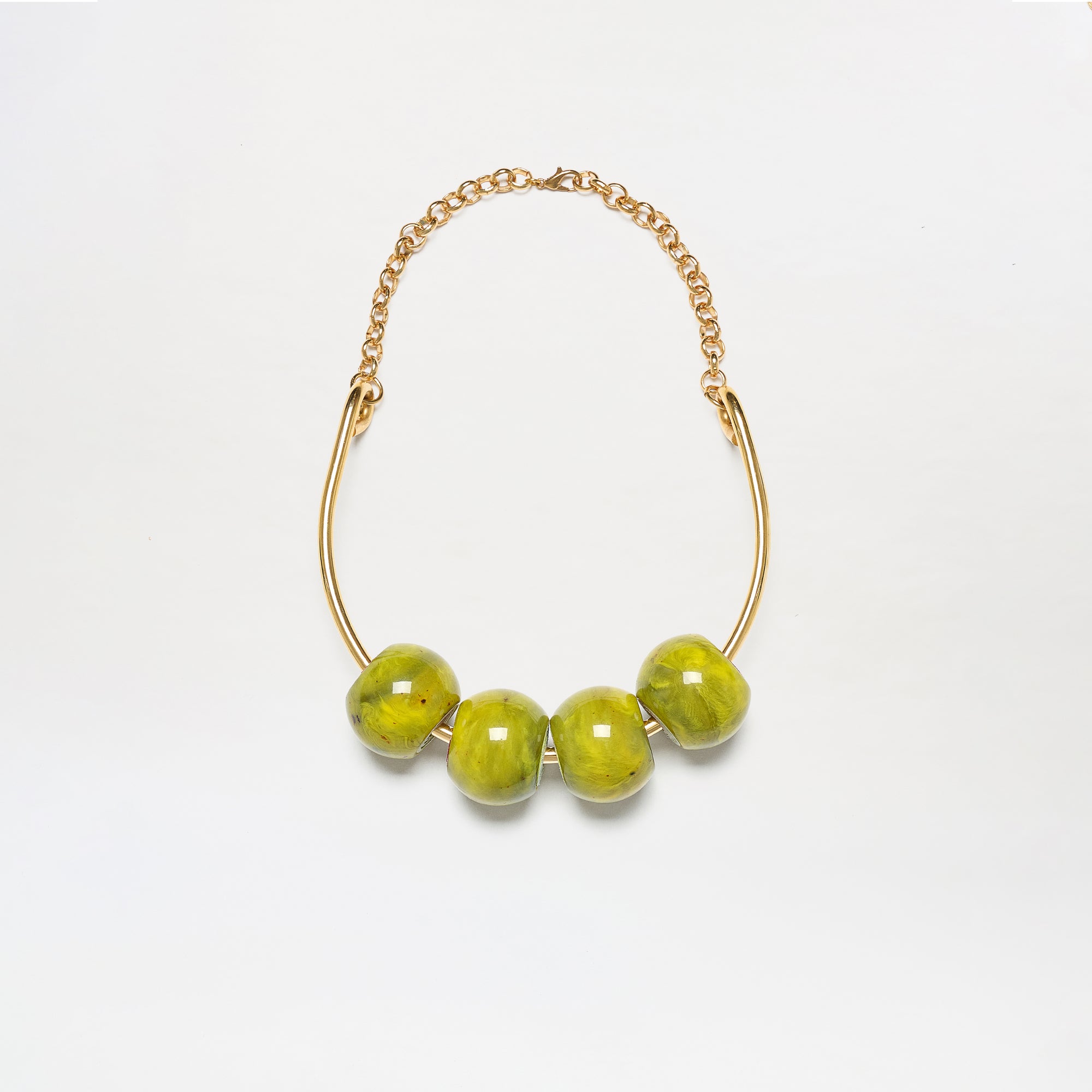 The Martini Chocker is a gold chain necklace featuring four large, glossy green beads on a curved gold bar, shown against a white background.
