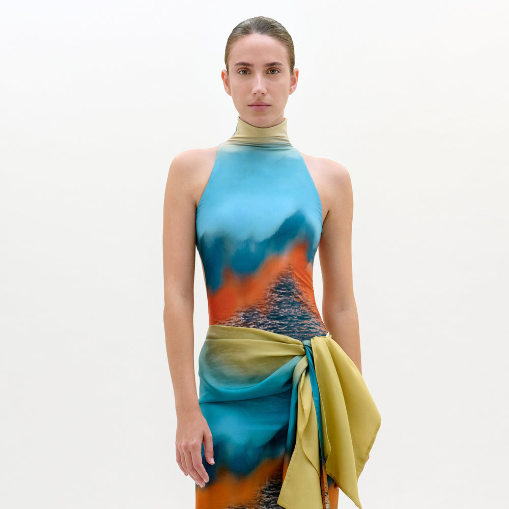 Model wearing a colorful dress with a gradient design on a plain background
