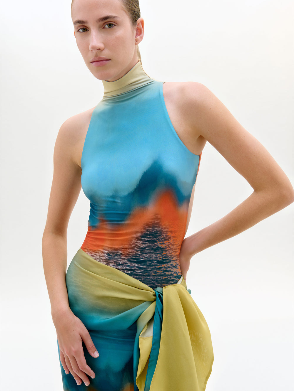 Model wearing a colorful sleeveless top with a gradient design on a white background