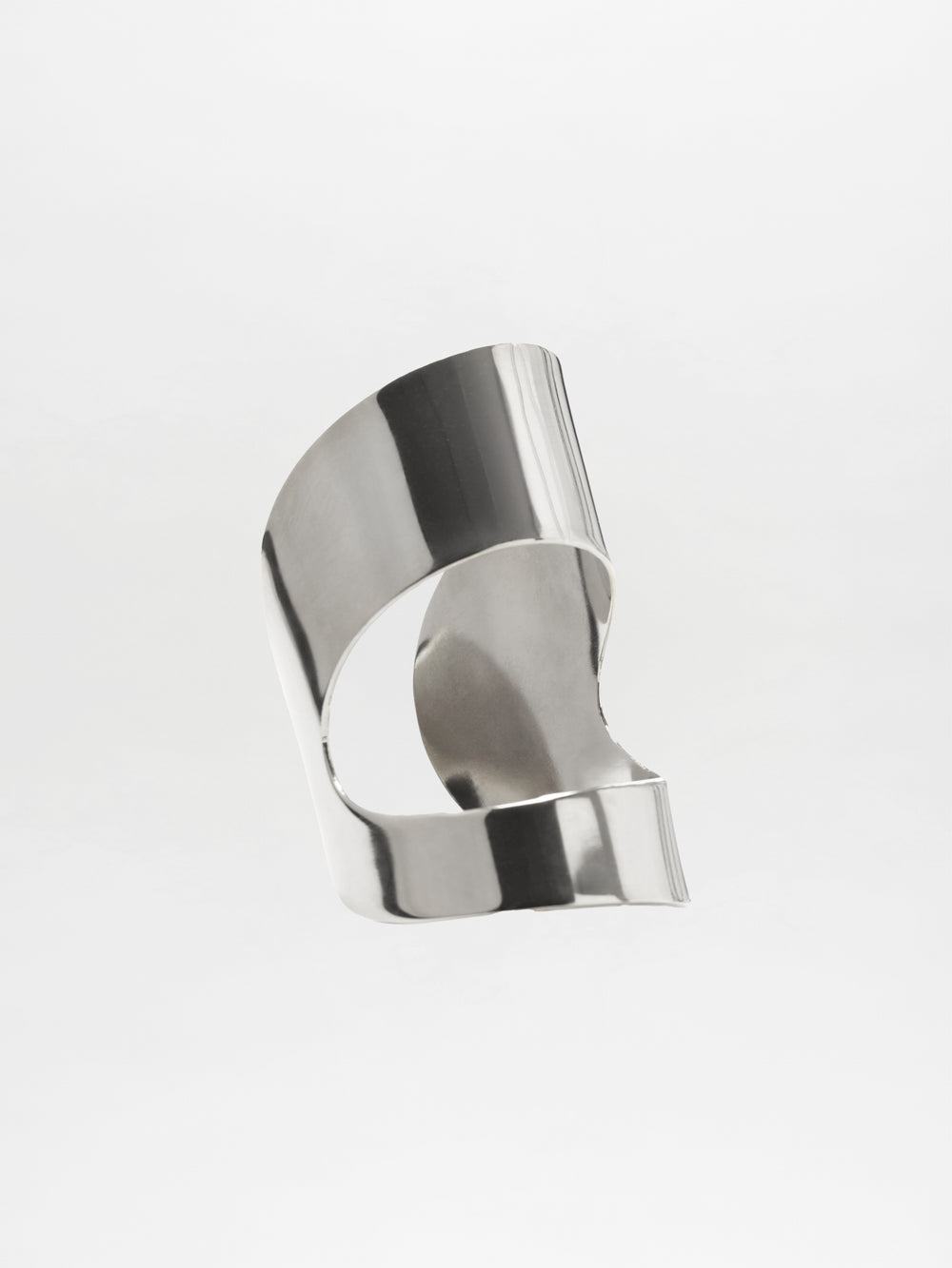 The Artemis Cuff is a sleek, modern accessory crafted from polished silver metal with smooth, curved lines and open spaces, displayed against a plain white background.