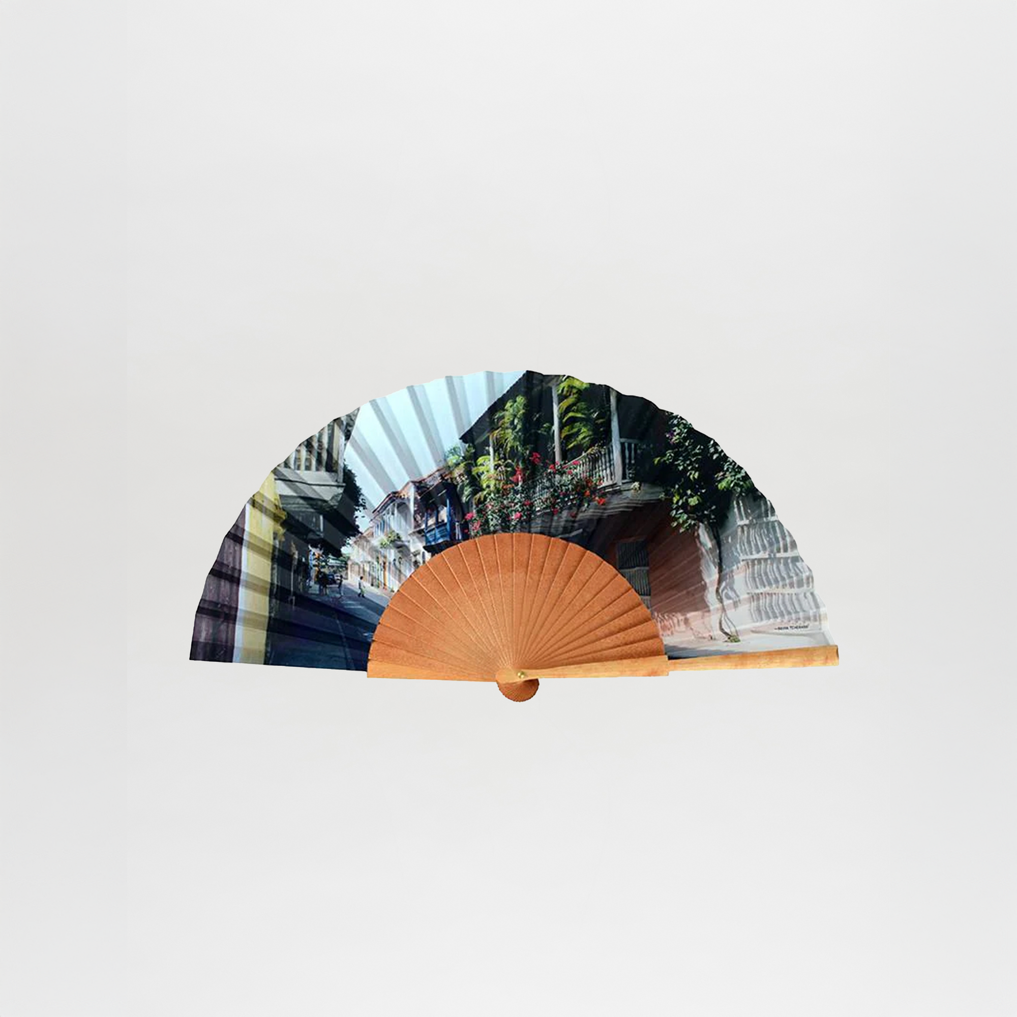The Balcones de Cartagena Fan is a handheld wooden fan with a paper leaf, adorned with colonial-style street scenes and lush greenery—an ideal Cartagena souvenir.