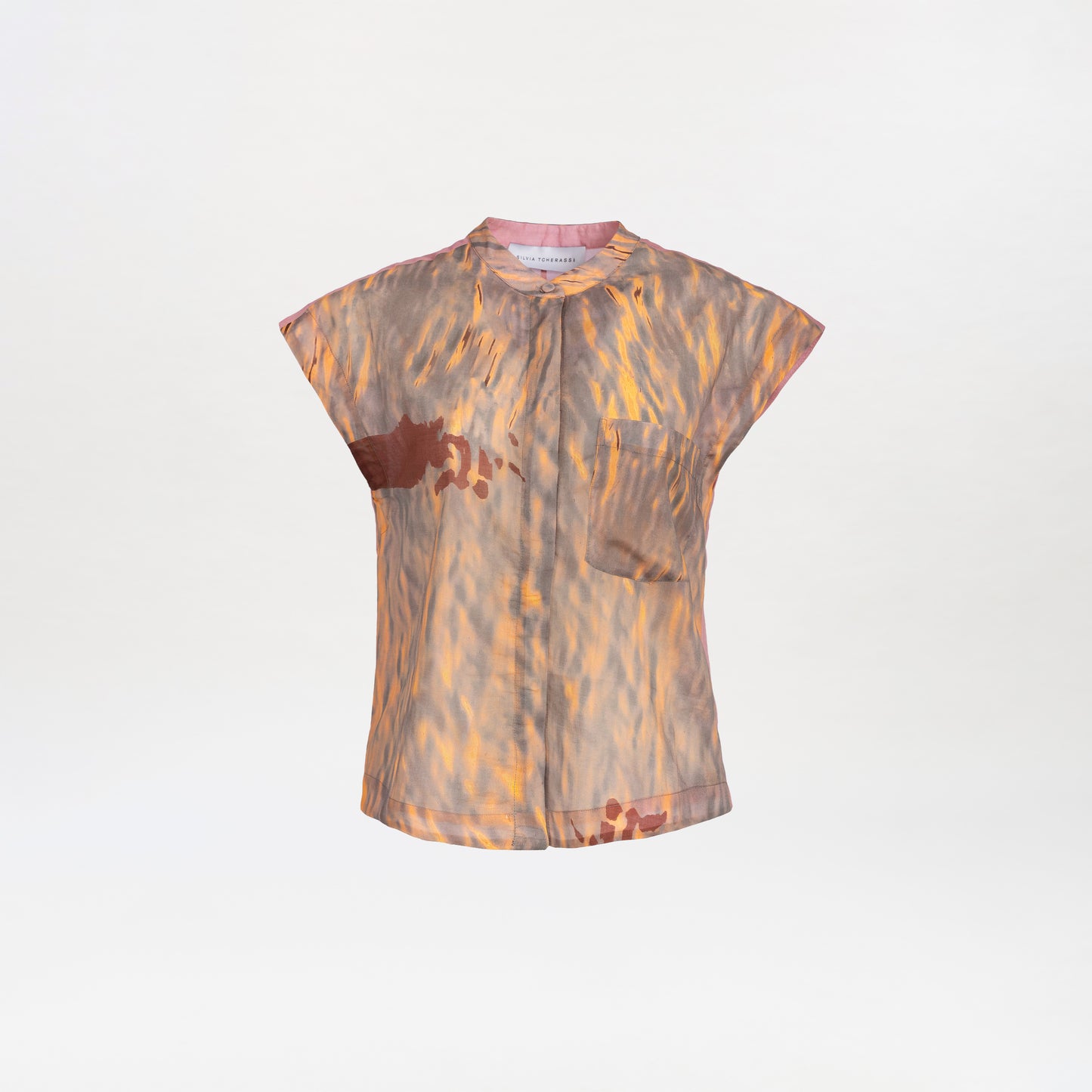 The Adele Blouse features a sheer, short-sleeve design with an abstract brown and orange pattern, a small chest pocket, and a mandarin collar, shown against a plain white background.