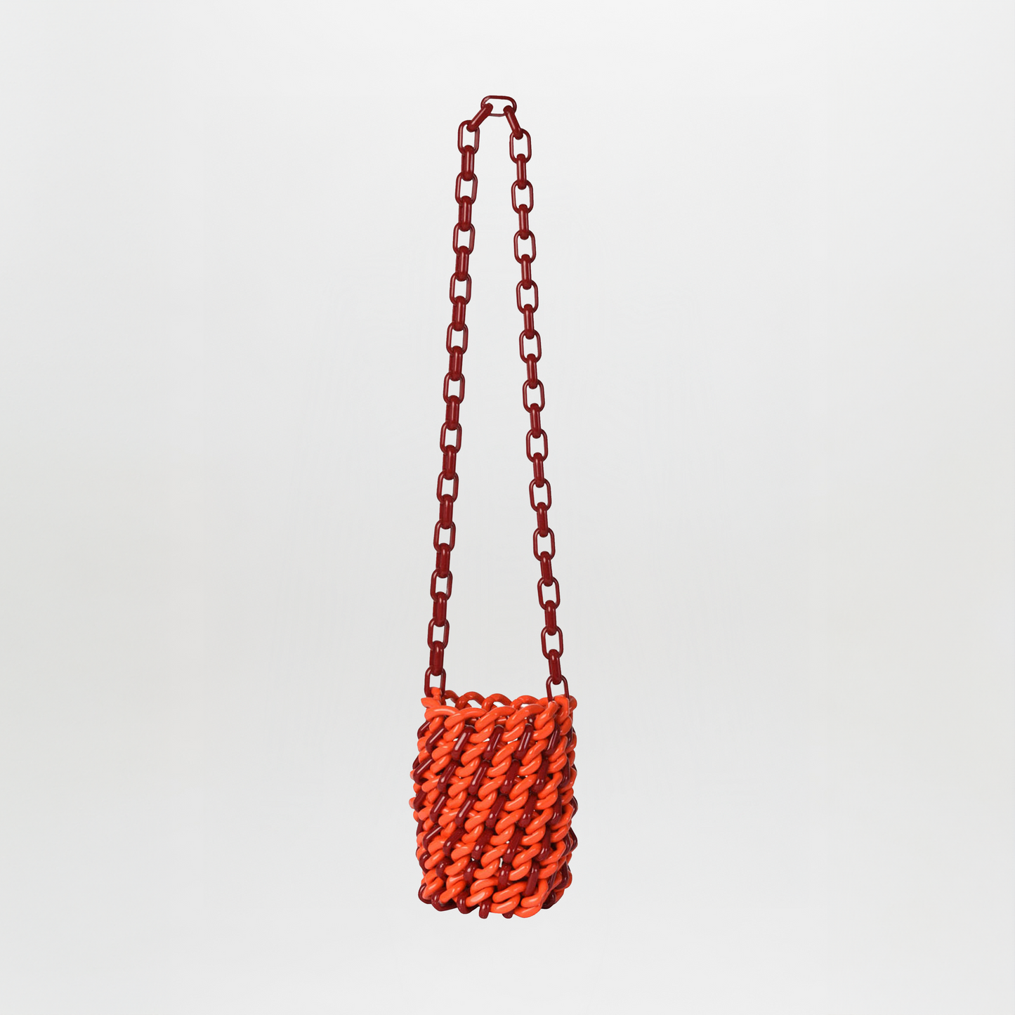 The Anise Bag Red is a small rectangular handbag with an orange resin body, chunky twisted design, and a long red chain strap, displayed against a plain white background.