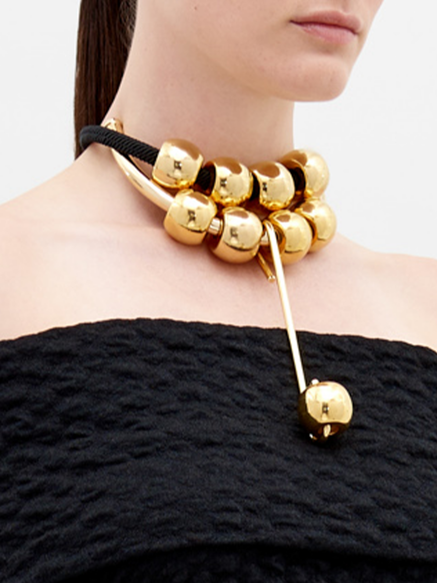 A Tristana Necklace Black with four large gold beads and an adjustable gold clasp, available for pre-order now with a ship date in early 2024.