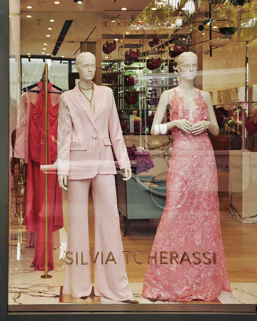 Mannequins wearing pink outfits in a store window with 'SILVIA TCHERASSI' branding.
