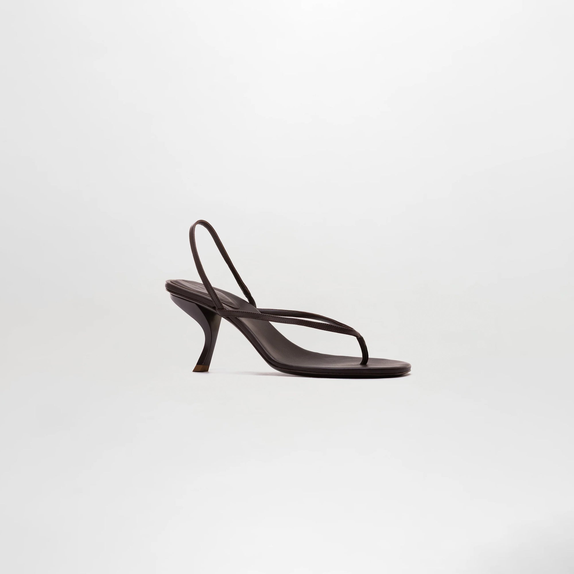 The Aurora Heels, dark brown sandals crafted from Italian leather with thin straps and a curved heel, are showcased against a plain light background.