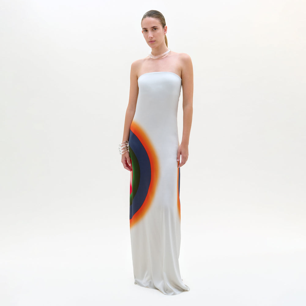 Woman wearing a strapless white gown with a colorful design on a white background
