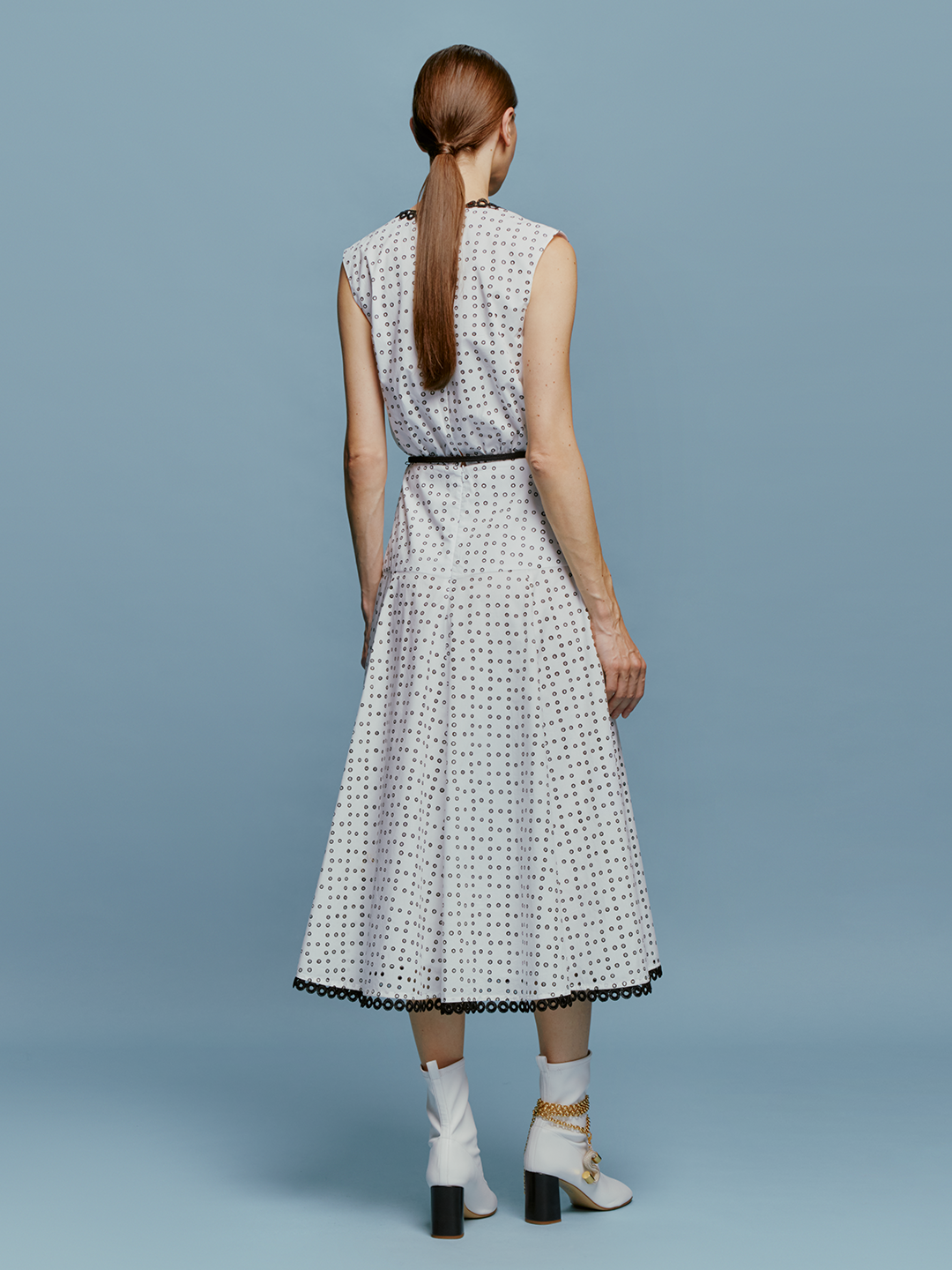 The model is wearing a Bora Dress White Black Dots.