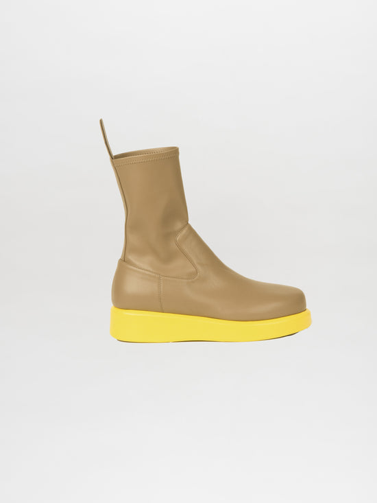 The Baia Boots Taupe Lemon showcase a soft stretch calf leather upper combined with a vibrant yellow platform sole, providing a fashion-forward appeal against a plain white background.