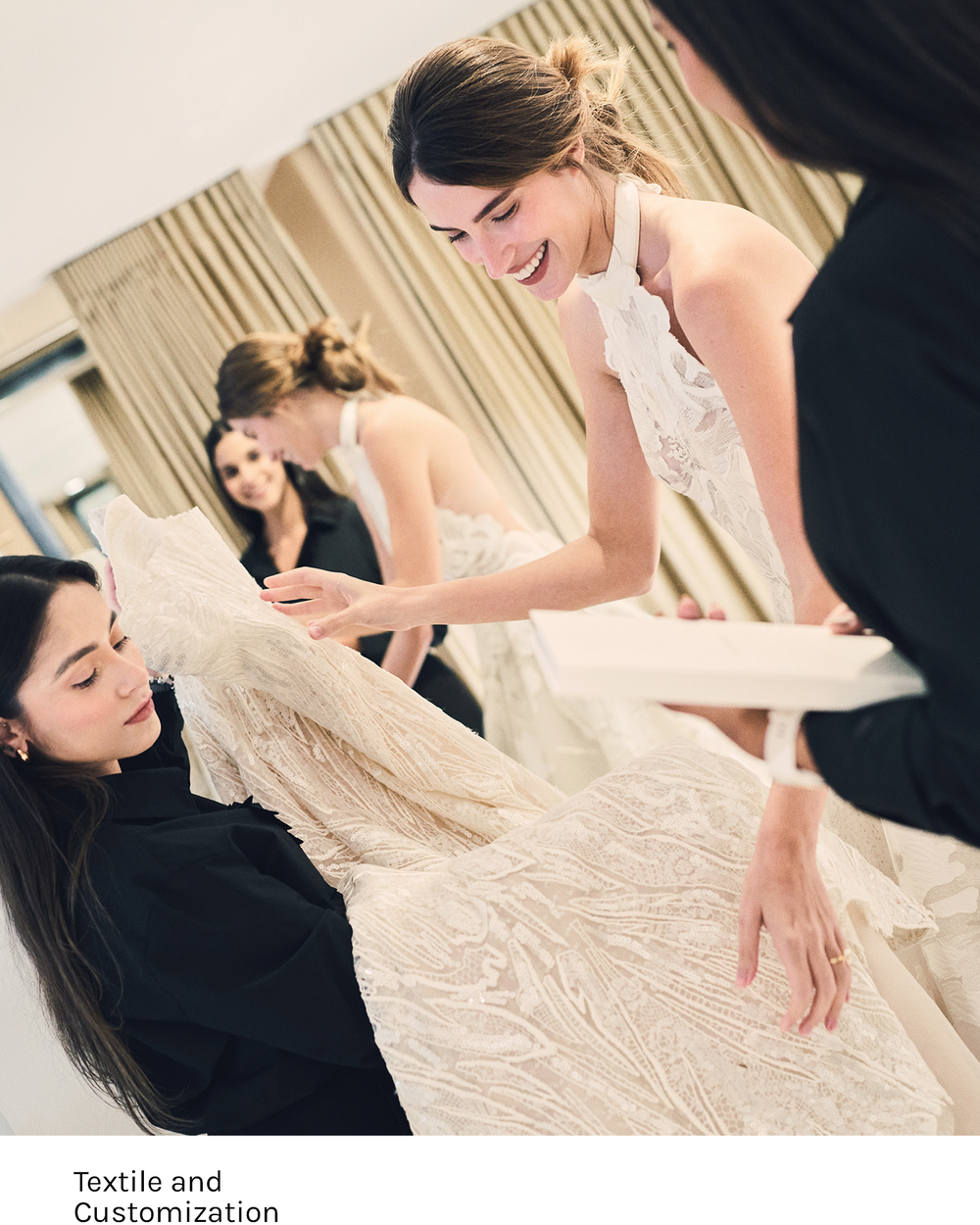 Woman trying on a wedding dress with assistance in front of a mirror.