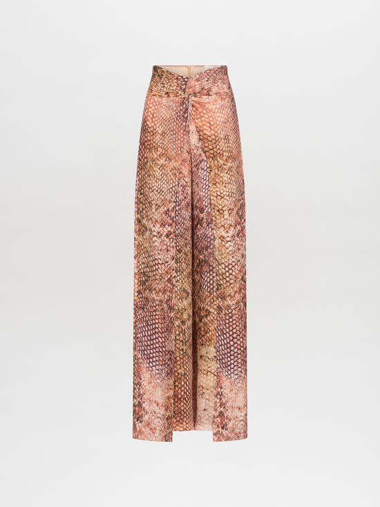 Person wearing a snakeskin-patterned outfit, consisting of a short-sleeve top and high-waisted, wide-leg Canturipe Pant Peach Animal Print, standing against a plain white background. This chic ensemble is available for pre-order and will ship by November 15th, 2024.