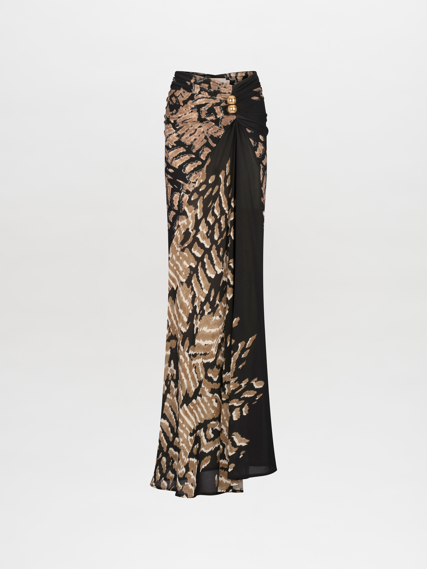 A woman stands wearing a long, fitted Claudia Skirt Black Abstract Animal Print. She has her hair pulled back and is accessorized with a gold necklace. Pre-order now to ensure delivery by the ship date of November 15th, 2024. The background is plain white.